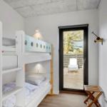 Room with bunk bed and door to terrace with lounge chair.