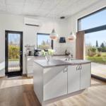 Kitchen with island, large windows, and view of the terrace.