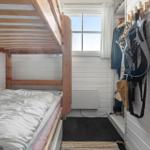 Small bedroom with bunk bed, window, and hooks on the wall.