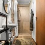 Bathroom with shower, sink, and mirror.