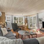 Living room with sofa, coffee table, and TV. Passage to dining area with table and chairs.