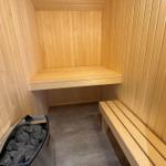 Sauna with wooden bench and stone bin