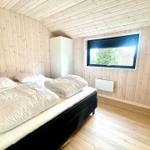 Bedroom with wooden walls, bed, and window