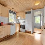 Küche mit Holzboden, hellen Schränken und moderner Küchenausstattung.