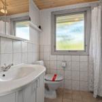 Badezimmer mit Waschbecken, Toilette und Dusche. Fenster mit Milchglas.