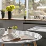 Rundtisch mit Tasse, Zeitschrift und Pflanzen vor Fenster