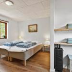 Schlafzimmer mit Doppelbett, Fenster und Regal mit Kisten.