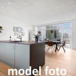 Küche mit Insel und Essbereich mit Blick auf Außenbereich.