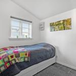 Schlafzimmer mit Bett, Fenster, Wandbild und TV