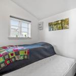 Schlafzimmer mit Bett, Fenster, Wandbild und TV.