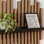 Wandregal mit Pflanze und gerahmtem Text an der Wand.