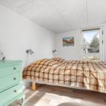 Schlafzimmer mit Bett, Kleiderschrank und Tür zum Garten.