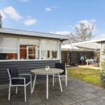 Terrasse mit Tisch und Stühlen, Gartenbereich mit Sonnenschirm und Grillplatz.