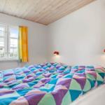 Schlafzimmer mit Bett, Fenster und Holzdecke.