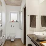 Badezimmer mit Waschmaschine, Toilette und Waschtisch