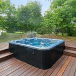 Hochwertige Whirlpool-Terrasse mit Holzdeck und grüner Umgebung.
