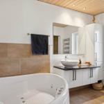 Bad mit Whirlpool, Waschbecken und Spiegelschrank.