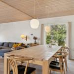 Essbereich mit Holztisch und Stühlen, Wohnbereich mit Sofa und Fensterblick.