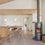 Wohn- und Essbereich mit Holzfußboden, Kamin und Essgruppe.