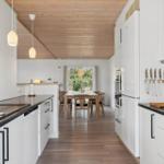 Küche mit Essbereich, Holzdecke und modernen Schränken.
