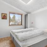 Bedroom with bed, window, and wooden floor.