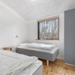 Room with two beds, window and wooden floor