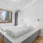 Bedroom with bed, window, and wardrobe.