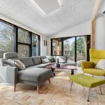 Living room with gray sofa, yellow chair, and wooden floor.