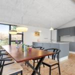 Kitchen and dining area with wooden floor, gray cabinets, and large window.