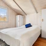 Bedroom with wooden walls, bed, window, and closets.