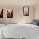 Two beds with white bedcovers, wooden walls and window