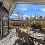 Deck with table and chairs, view of garden and sky