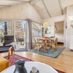 Living and dining area with wood walls, table, chairs, and view of the garden.