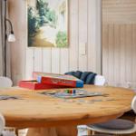 Round wooden table with toys and chairs in a room with wooden walls.