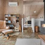 Living room with wood wall, armchair, fireplace, and bookcase.