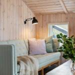 Living room with sofa, plant, and TV on wood wall