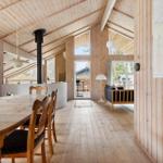 Wooden house with dining area, living area, and fireplace.