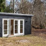 Black wooden house with white glass doors in the forest