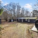 Wooden house with garden, sauna, and barbecue area in the forest.