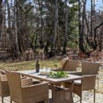 Wooden terrace with dining table and chairs in the woods