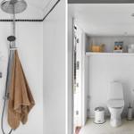 Shower with rain showerhead and brown towel. Toilet and sink with wooden shelf.