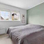 Bedroom with bed, window, and wall decor.