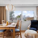 Dining room with wooden table, chairs, and view of outdoor area.