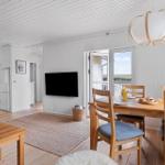 Living and dining area with wooden table, TV, and balcony view.