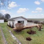 House with terrace, garden, and view of fields.