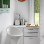 Kitchen area with white countertop, blender, and window view.