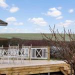 Deck with white garden furniture and view of fields.