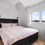 Bedroom with bed, windows, and ceiling light.