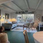 Living room with sofa, seating group, and fireplace. Garden view from window.