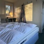 Bedroom with bed, window, and wall hooks.